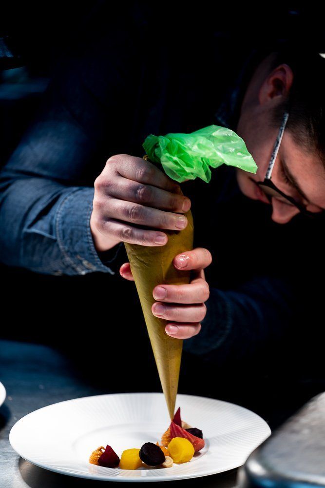 A chef piping sauce