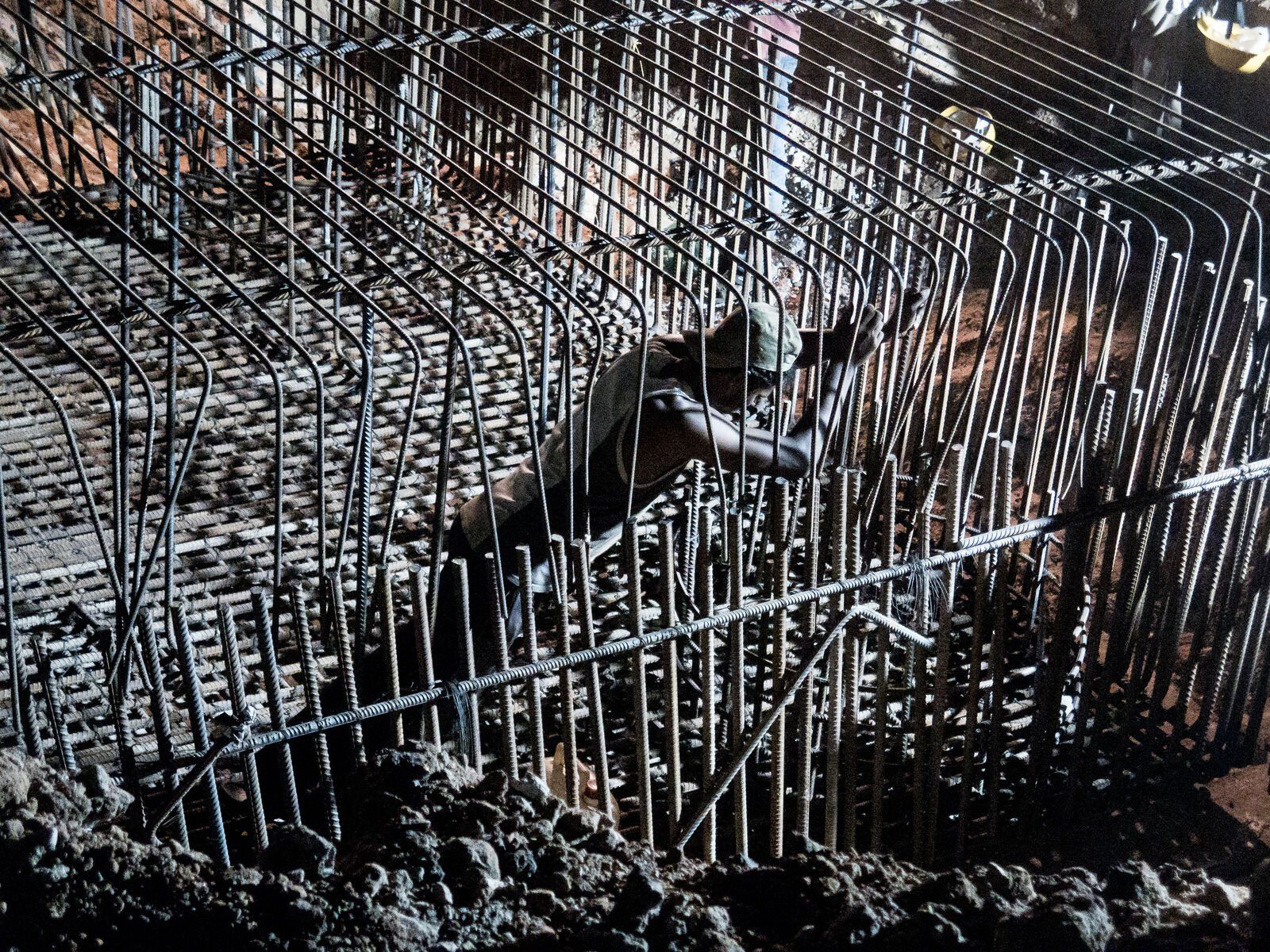 A figure behind a wall of metal grates