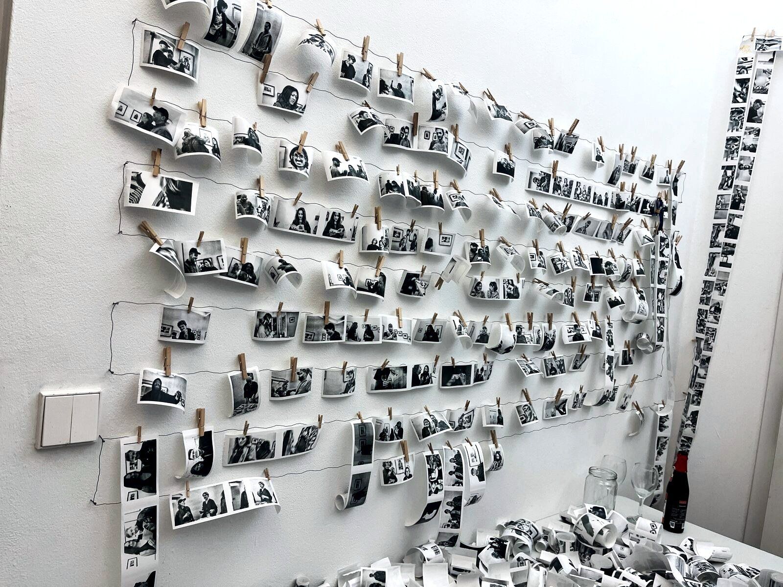A gallery wall covered in hundreds of small thermal portrait prints