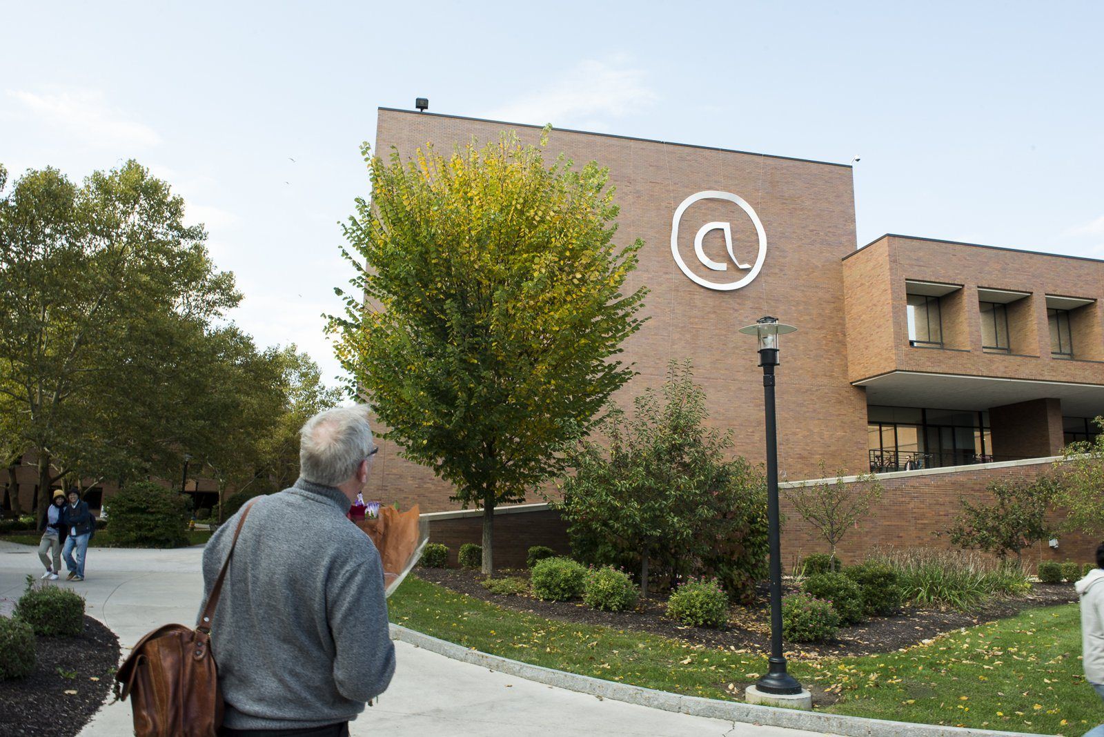 A giant @ sign mounted on the side of an RIT building