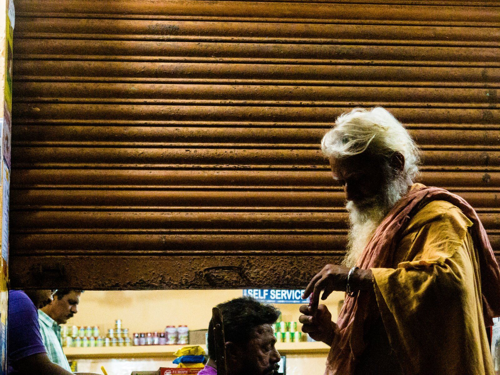 A holy man in saffron in the light of a doorway