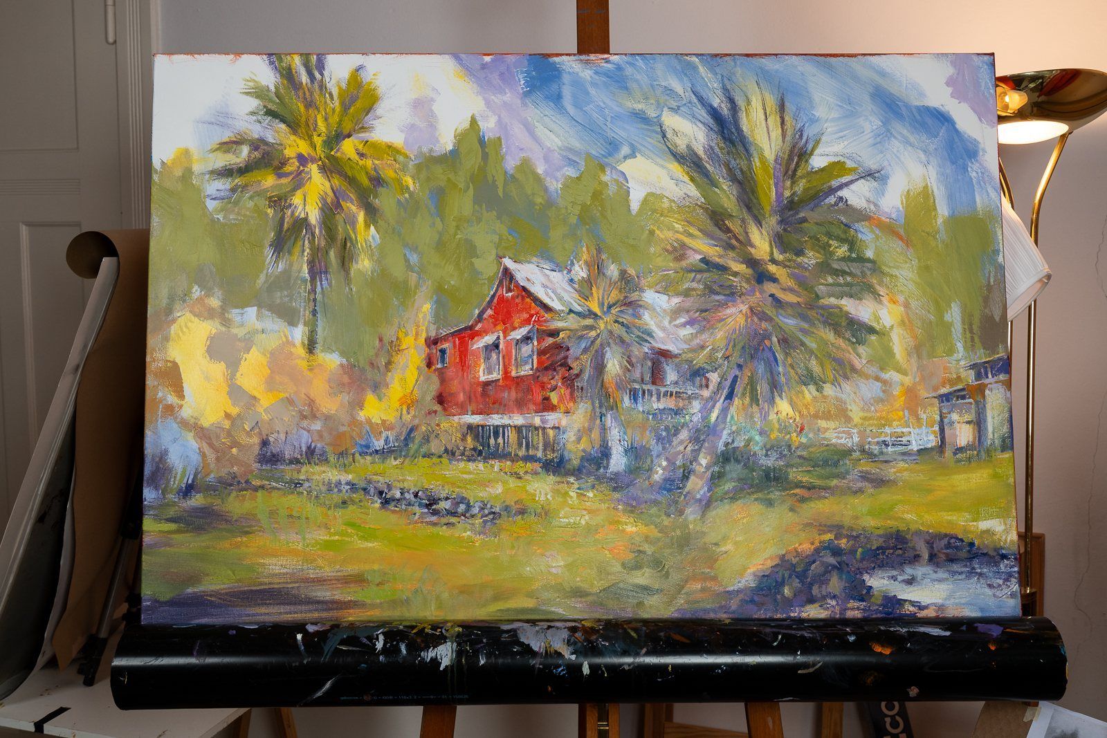 A landscape with a red house and palms, on the easel