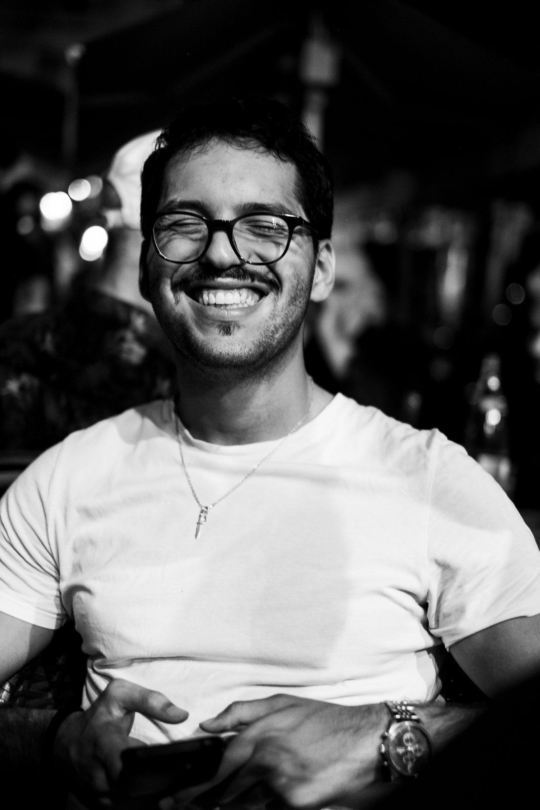 A man laughing at a table at night