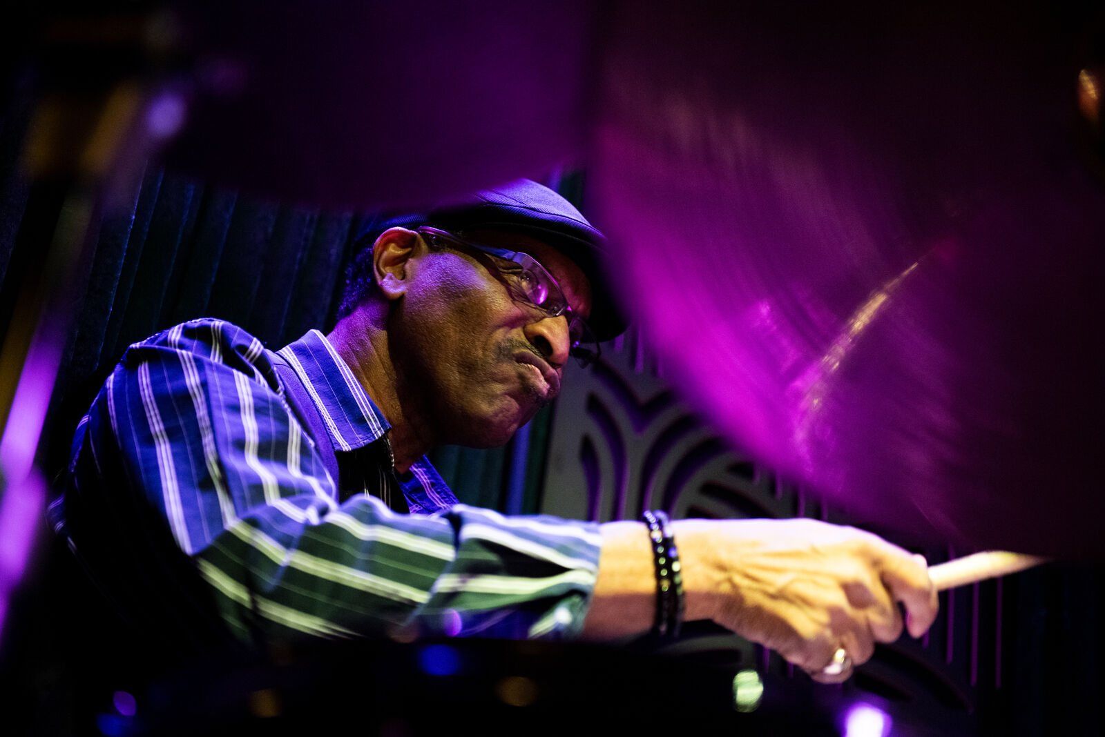 A pianist pointing across the keys in purple light