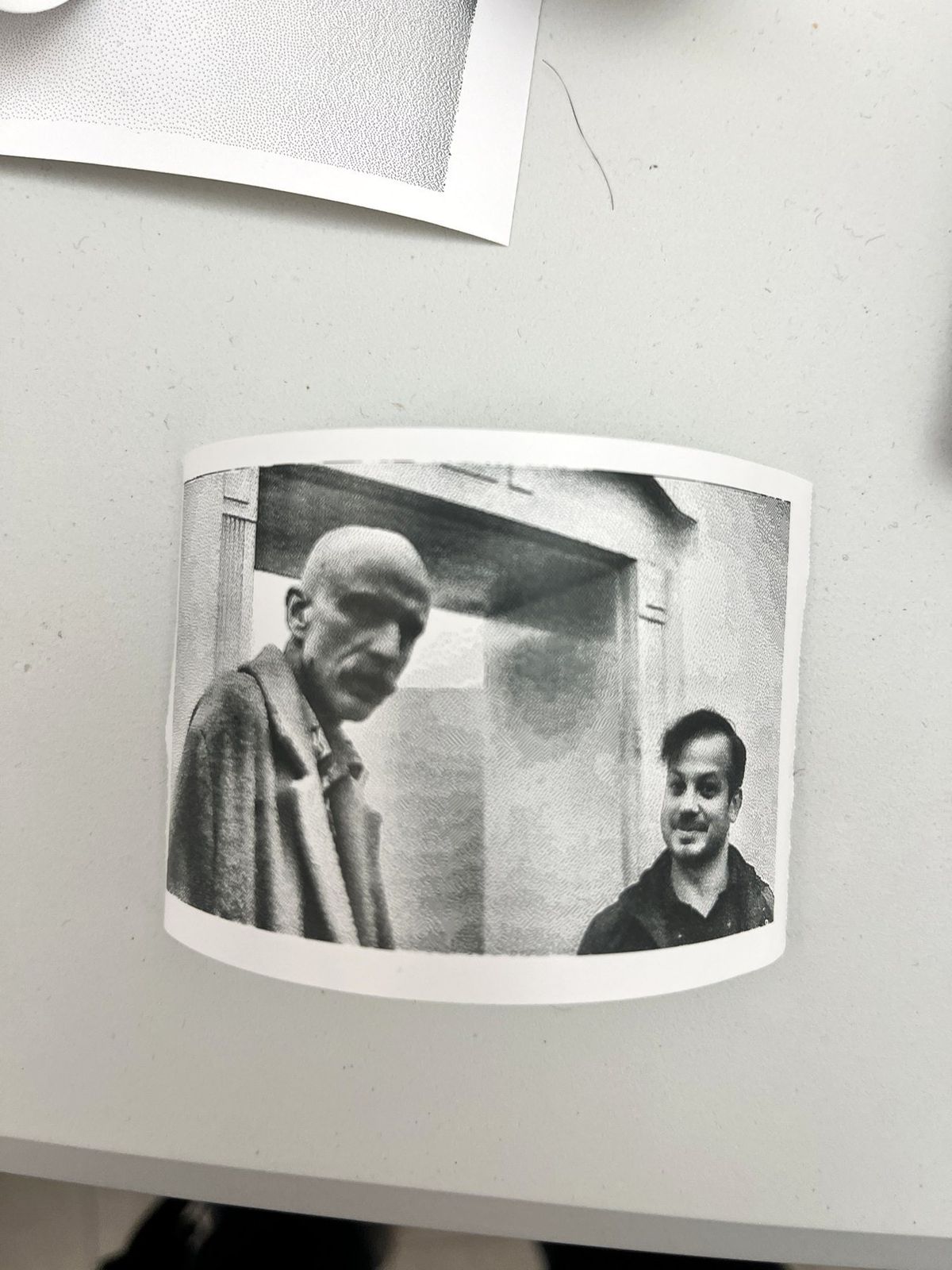 A pile of curling thermal strips with printed portraits