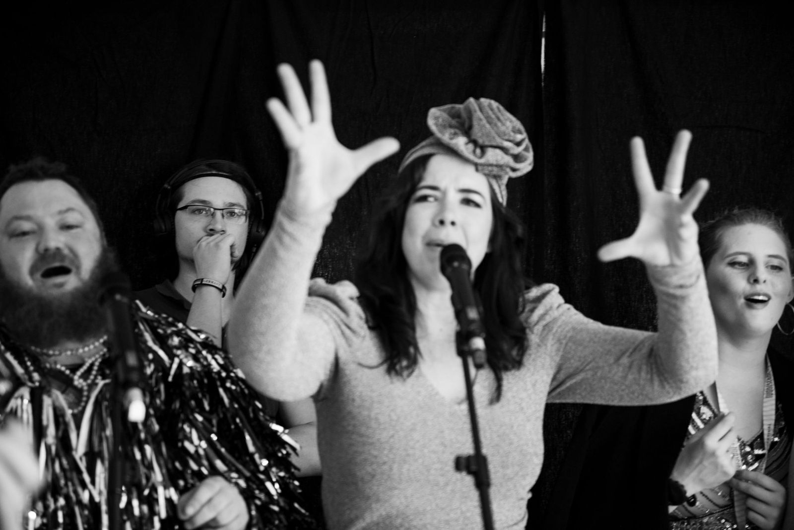 A singer with her hands thrown up during the radio session, black and white