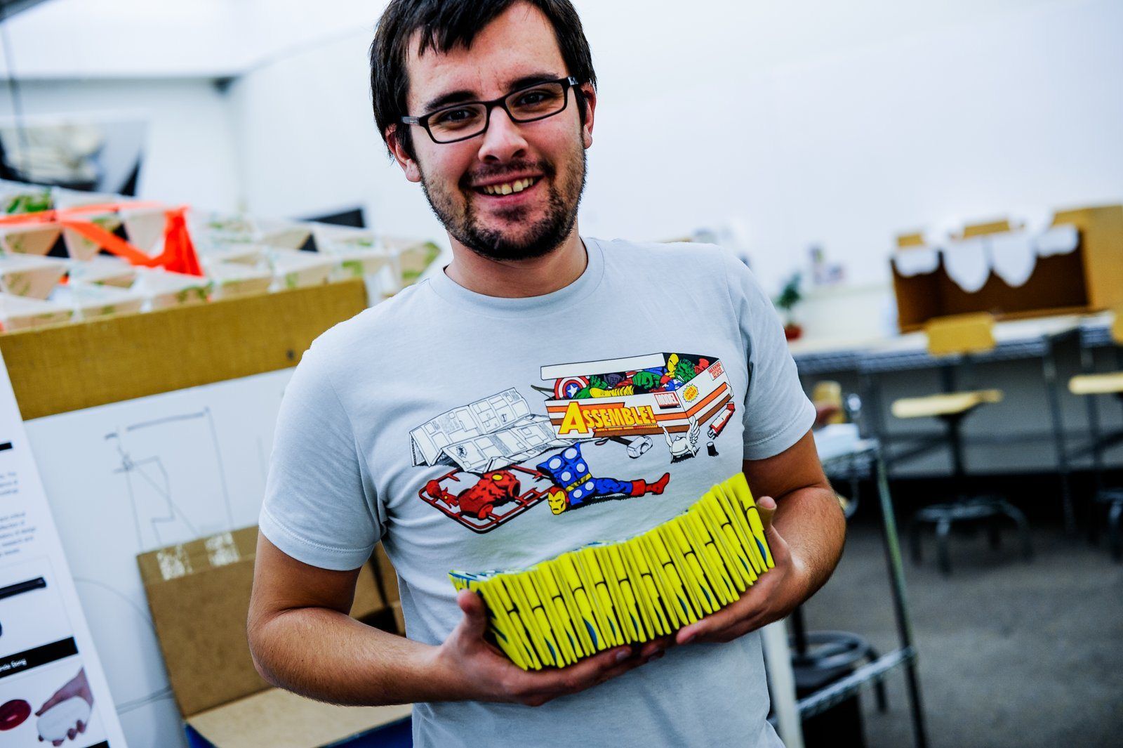 A student holding a stack of the yellow Thought at Work wallets