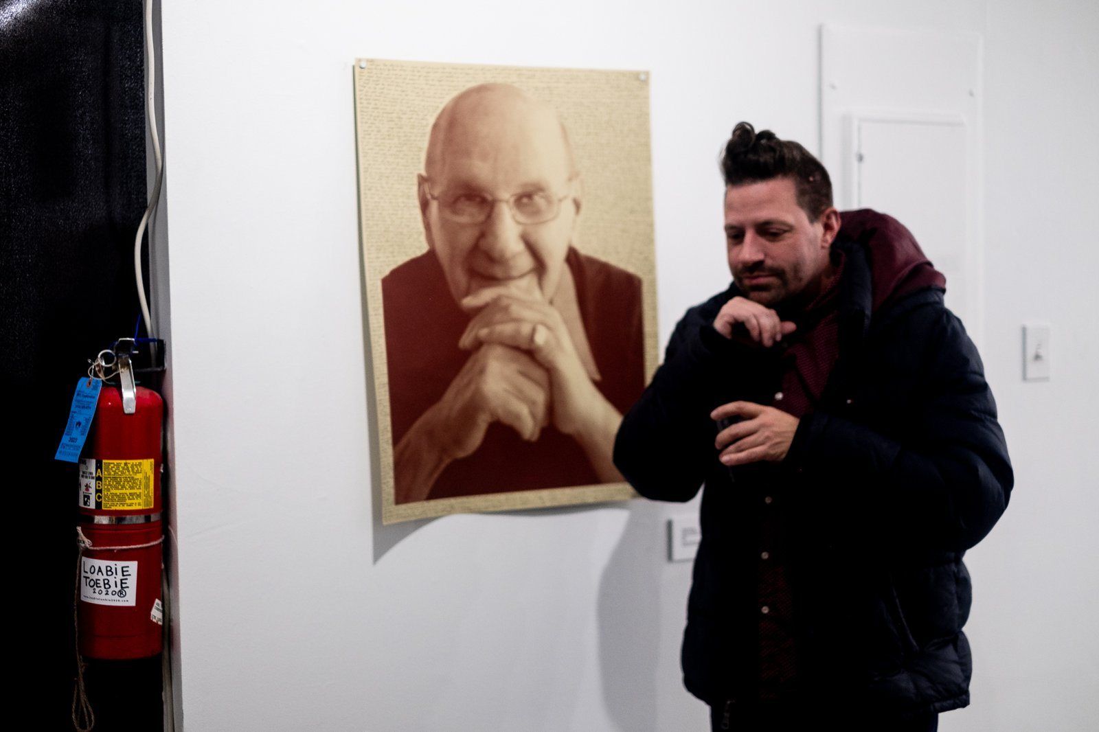 A visitor laughing beside a painted portrait