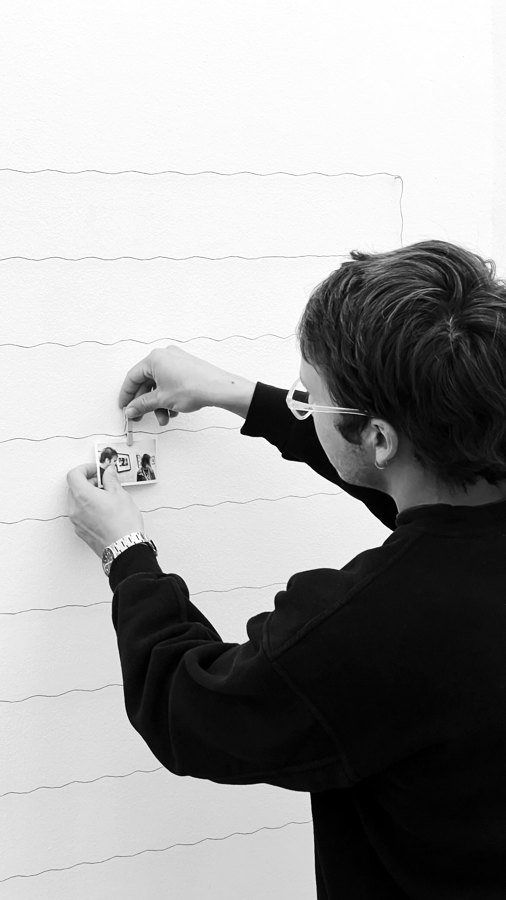 A visitor pinning a strip to the wire