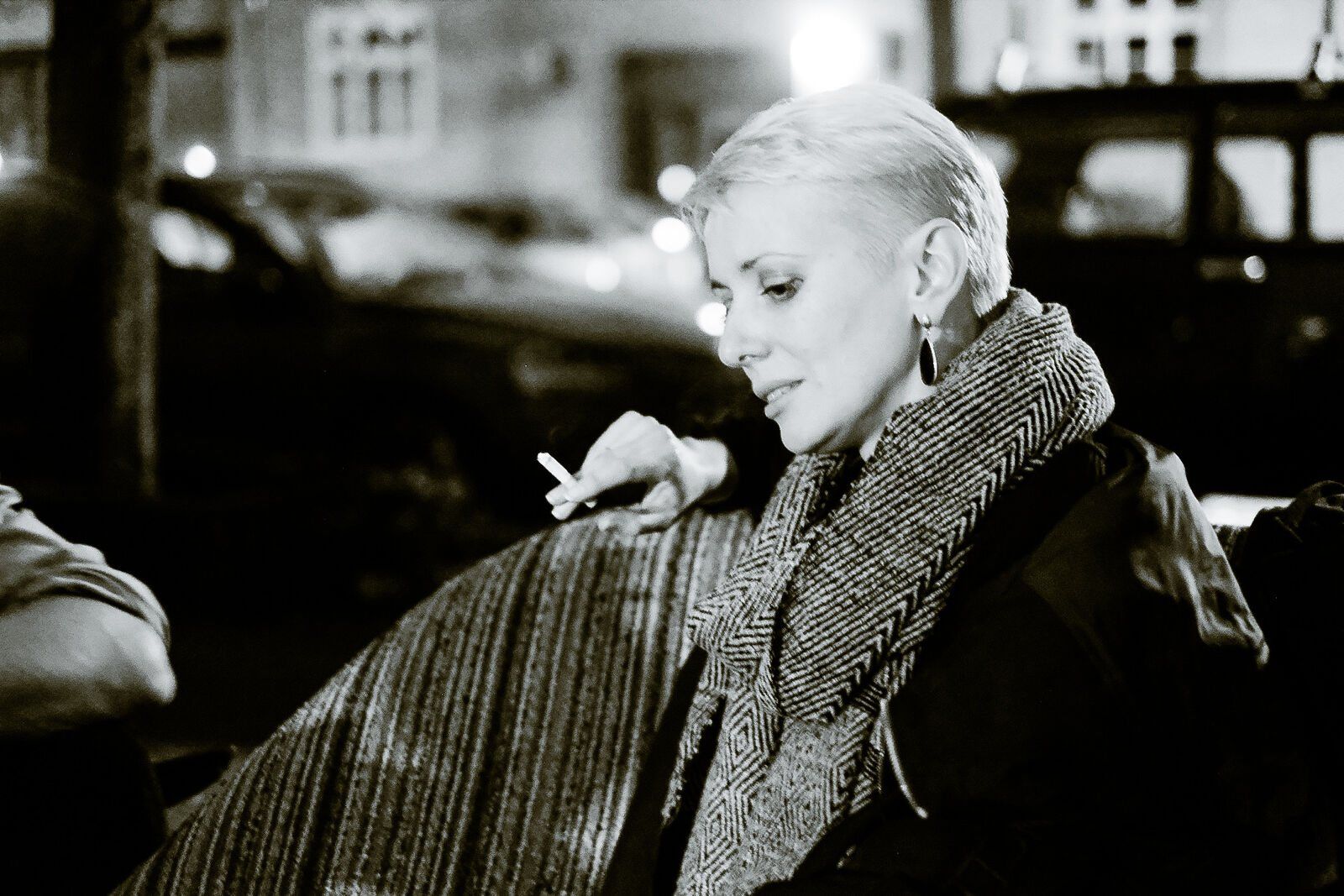 A woman in a herringbone scarf at night, black and white