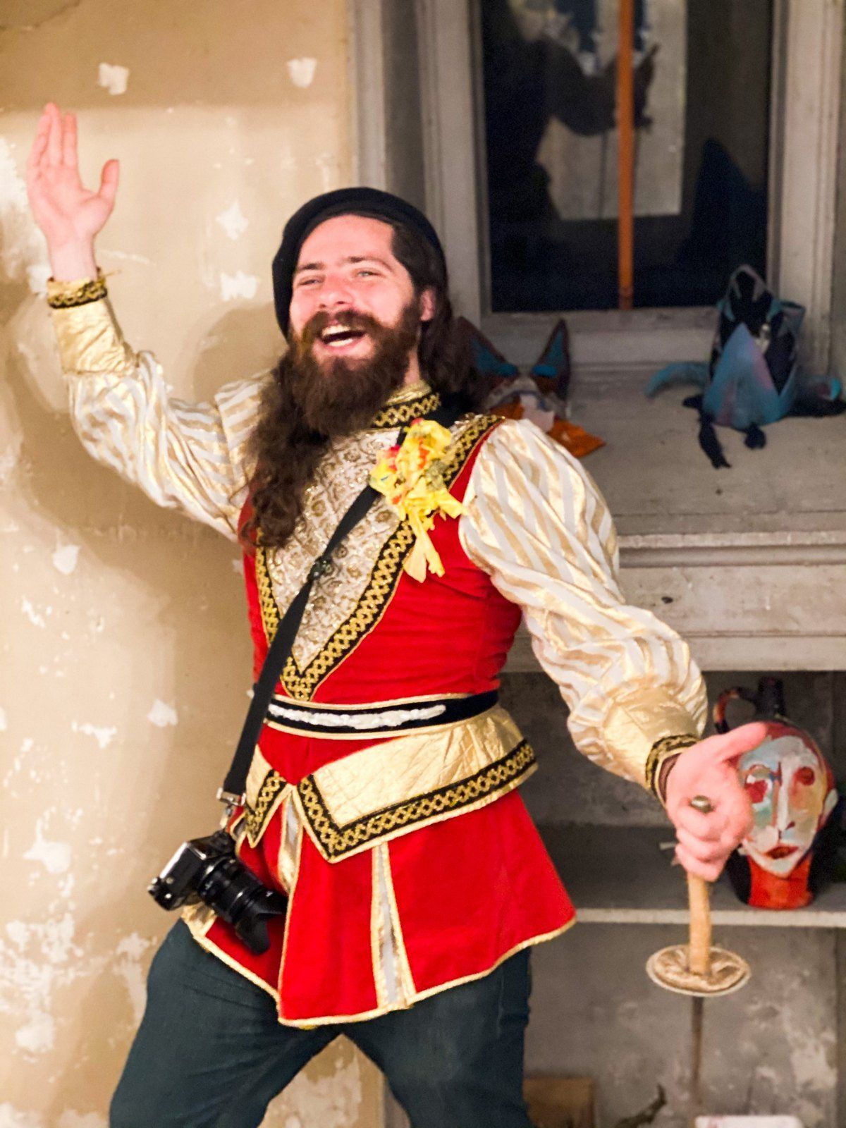 Aaron laughing in a red and gold costume, camera on his shoulder