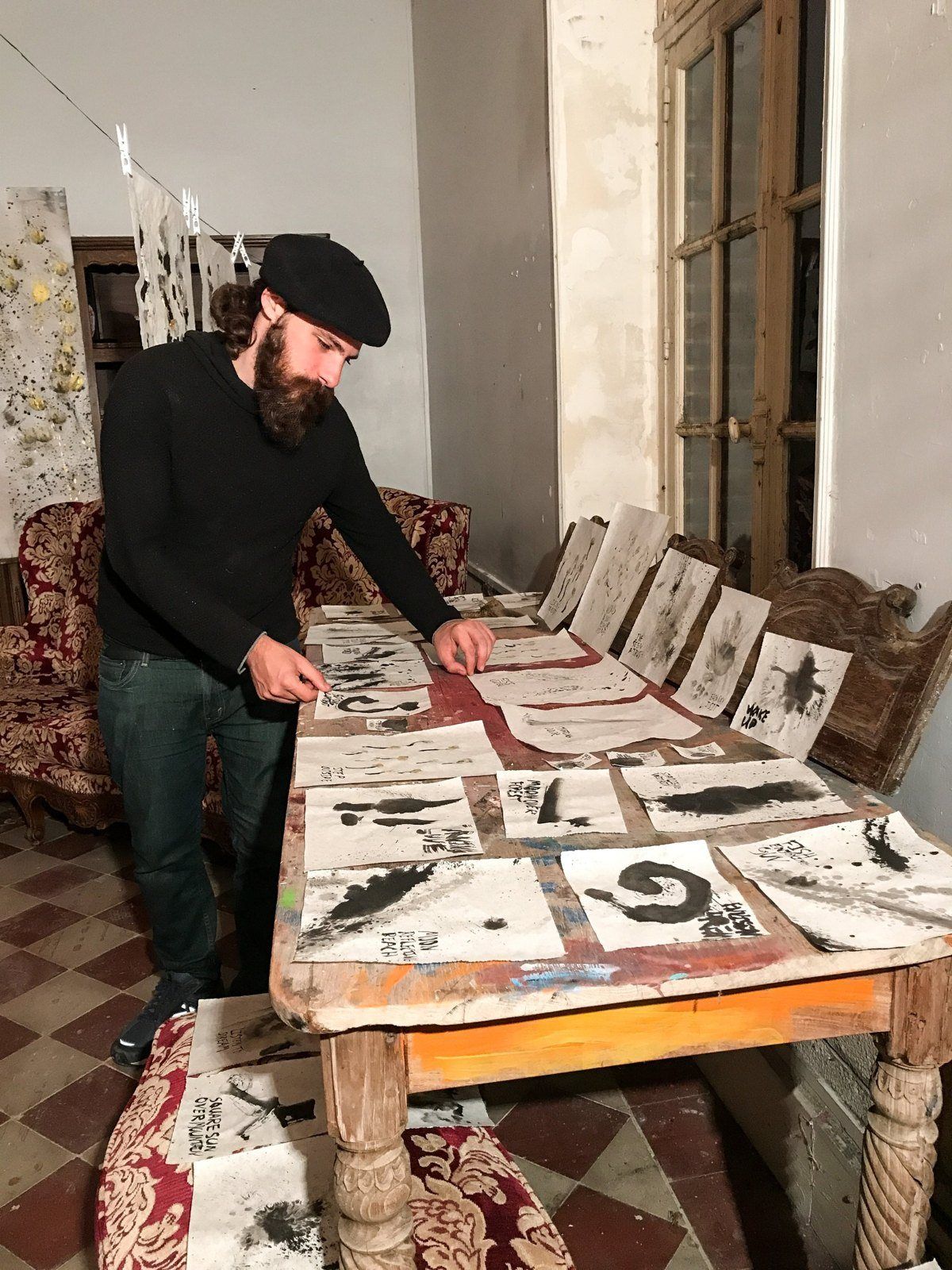 Aaron laying out sumi ink works on a long wooden table