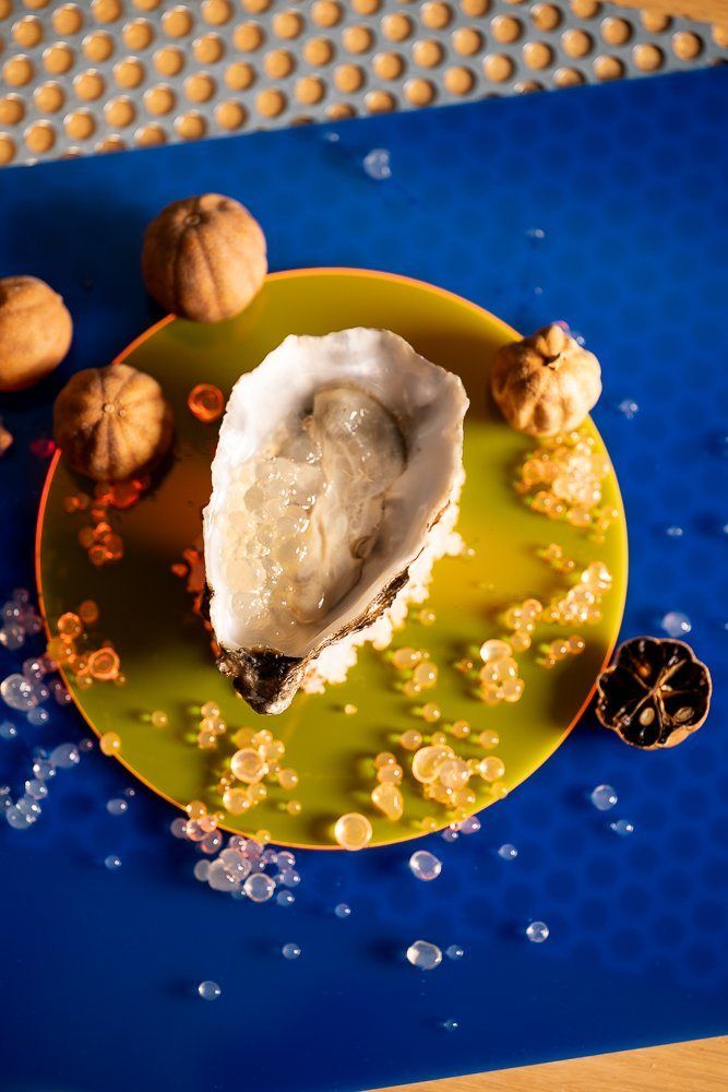An oyster on a deep blue plate