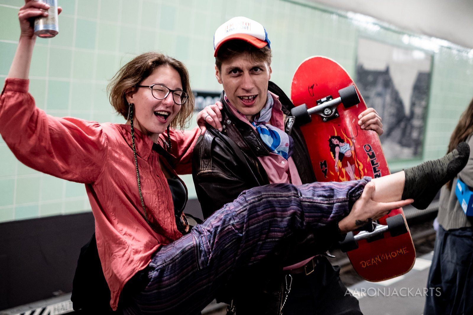 Friends laughing with a skateboard on a U-Bahn platform