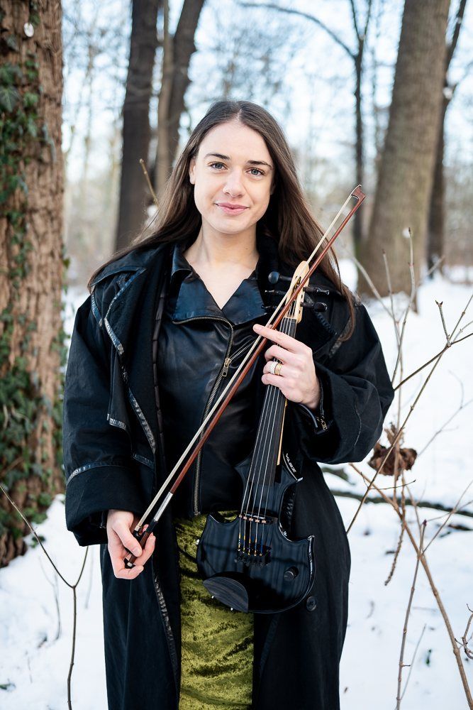 Julia in a long coat with violin and bow