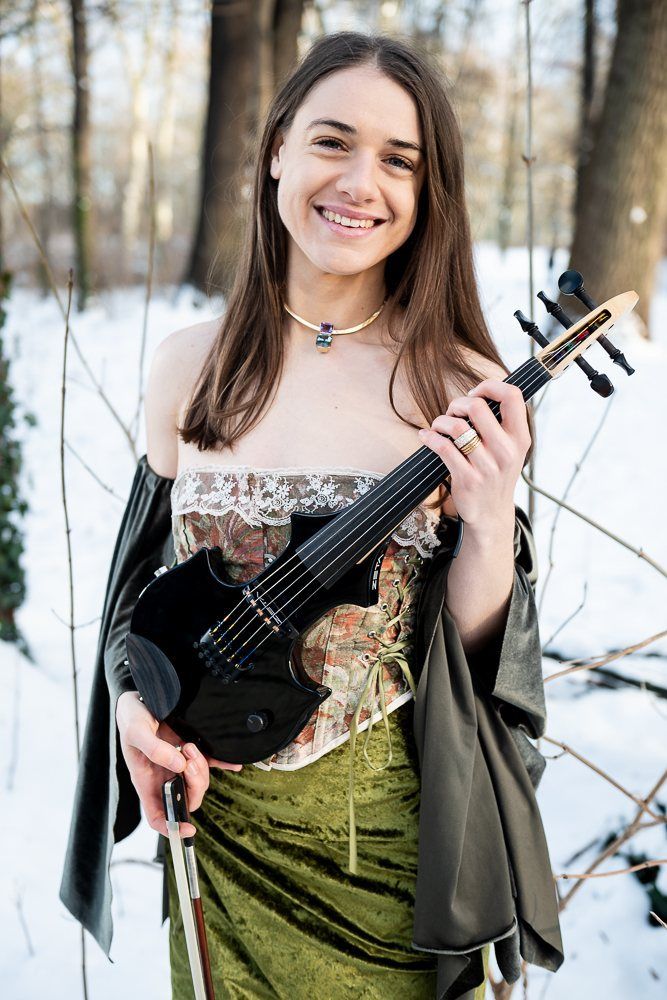 Julia laughing with the violin, snow behind her