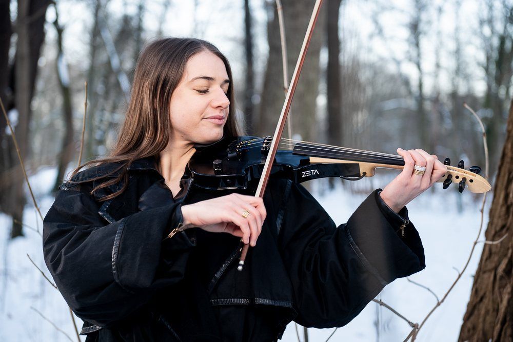 Julia Sandros playing her electric violin in the snow