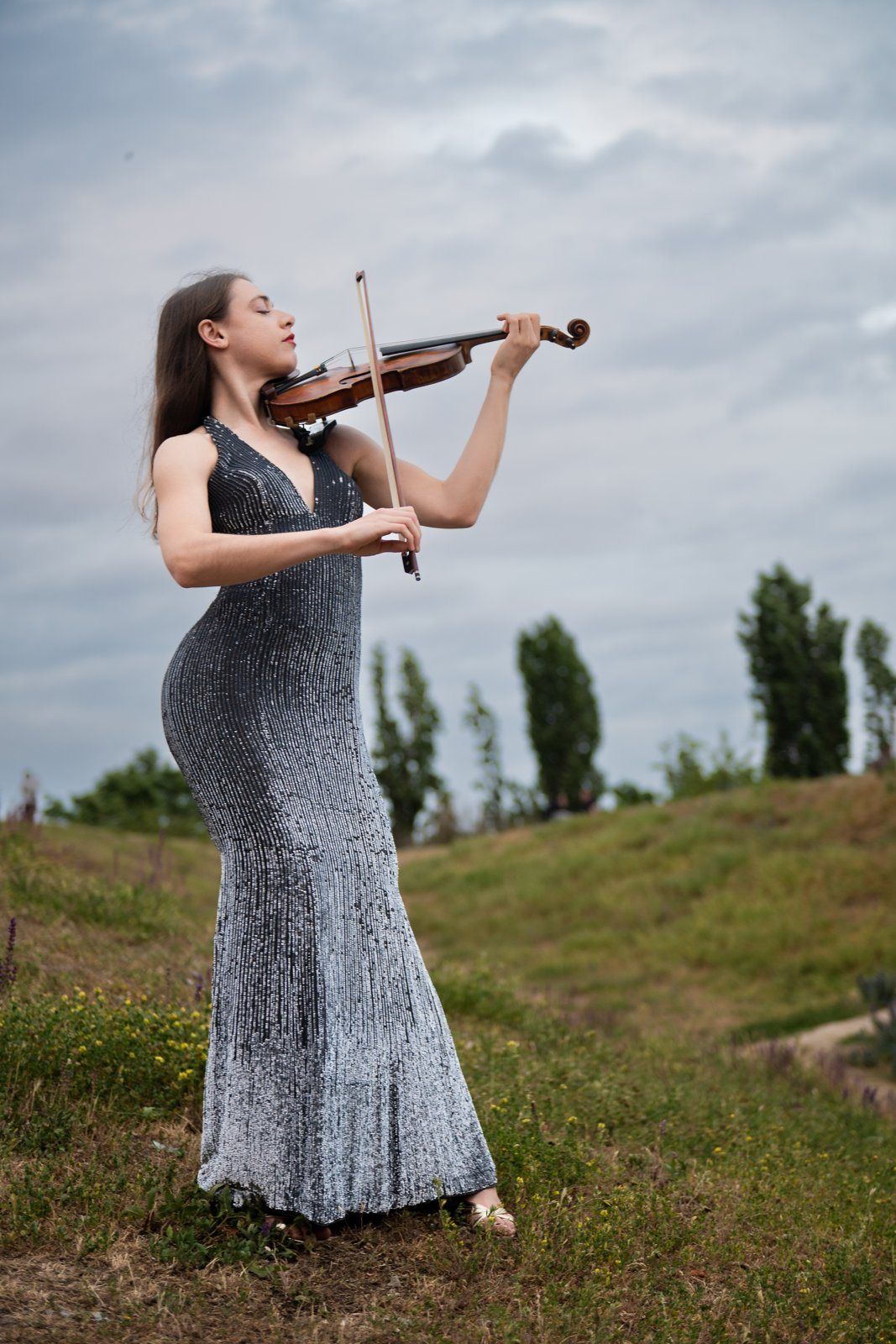 Julia Sandros playing violin on the hill