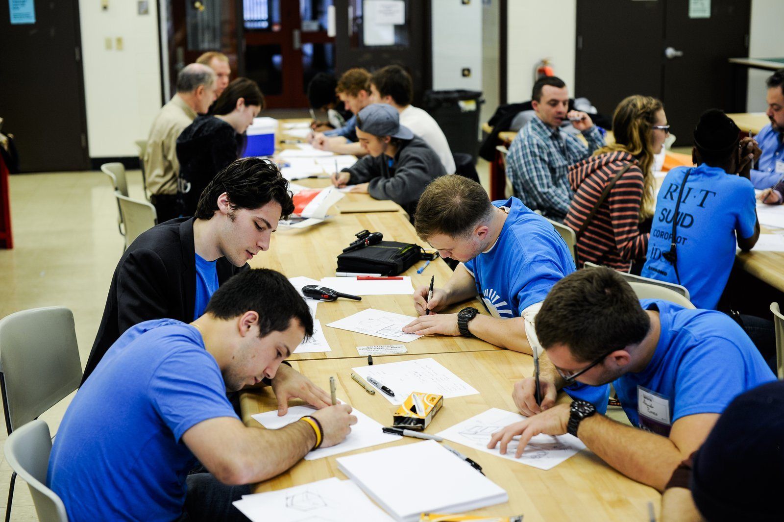 Students working at long tables during a Thought at Work workshop