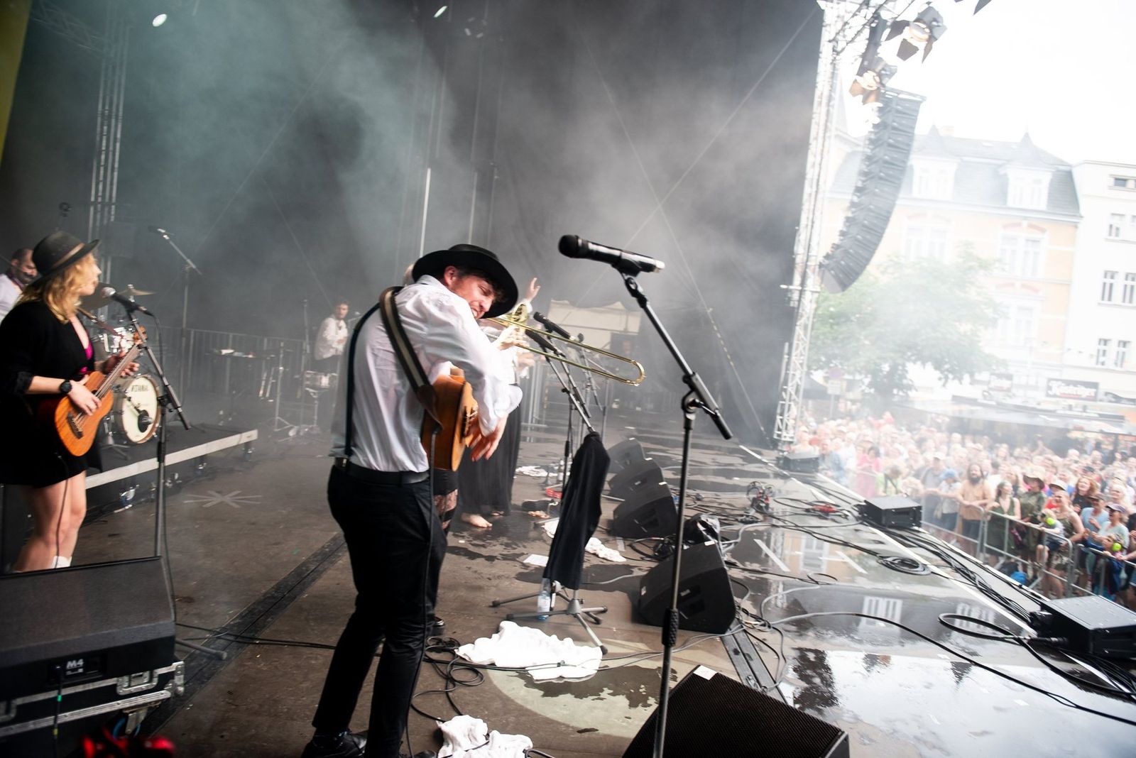 The band on the festival stage seen from the wings, the crowd beyond