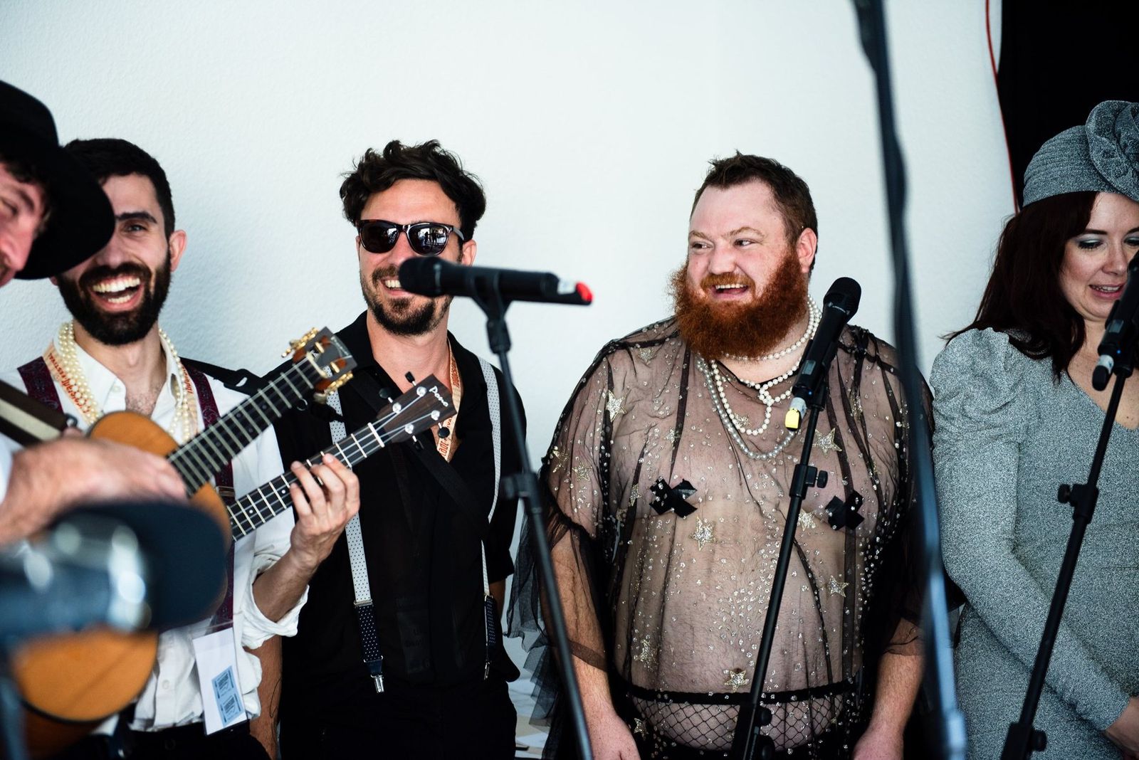 The band playing live for the radio around one microphone