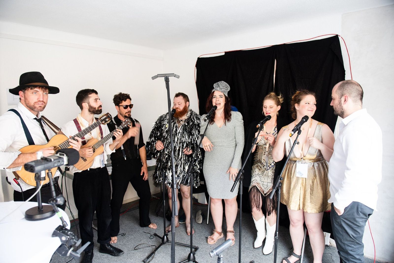The whole band crowded around the microphones in a small white radio studio