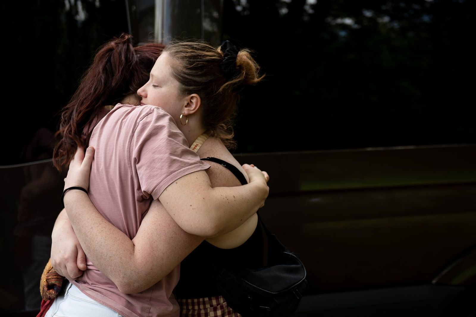 Two band members hugging beside the van