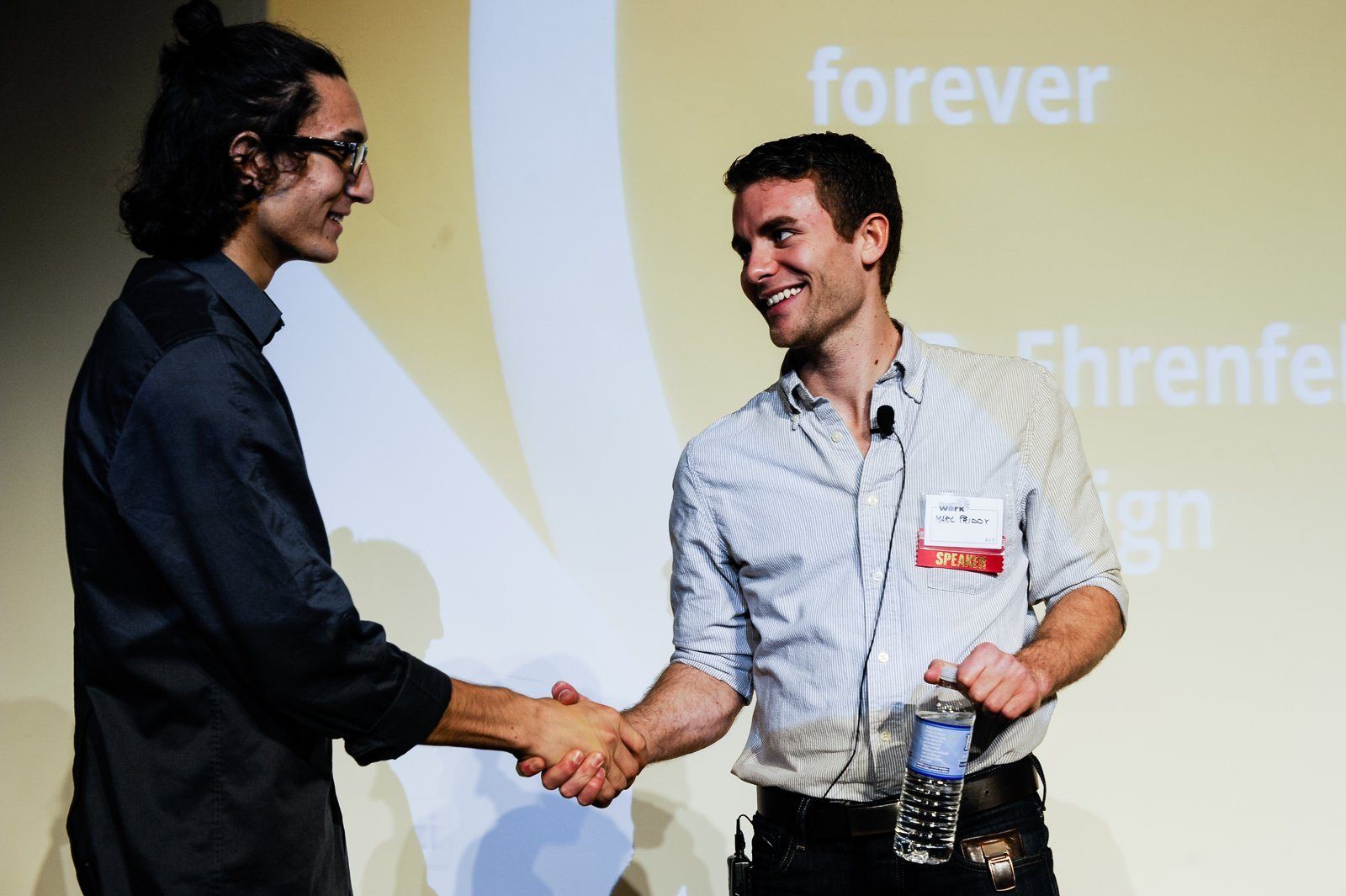 Two people shaking hands on stage