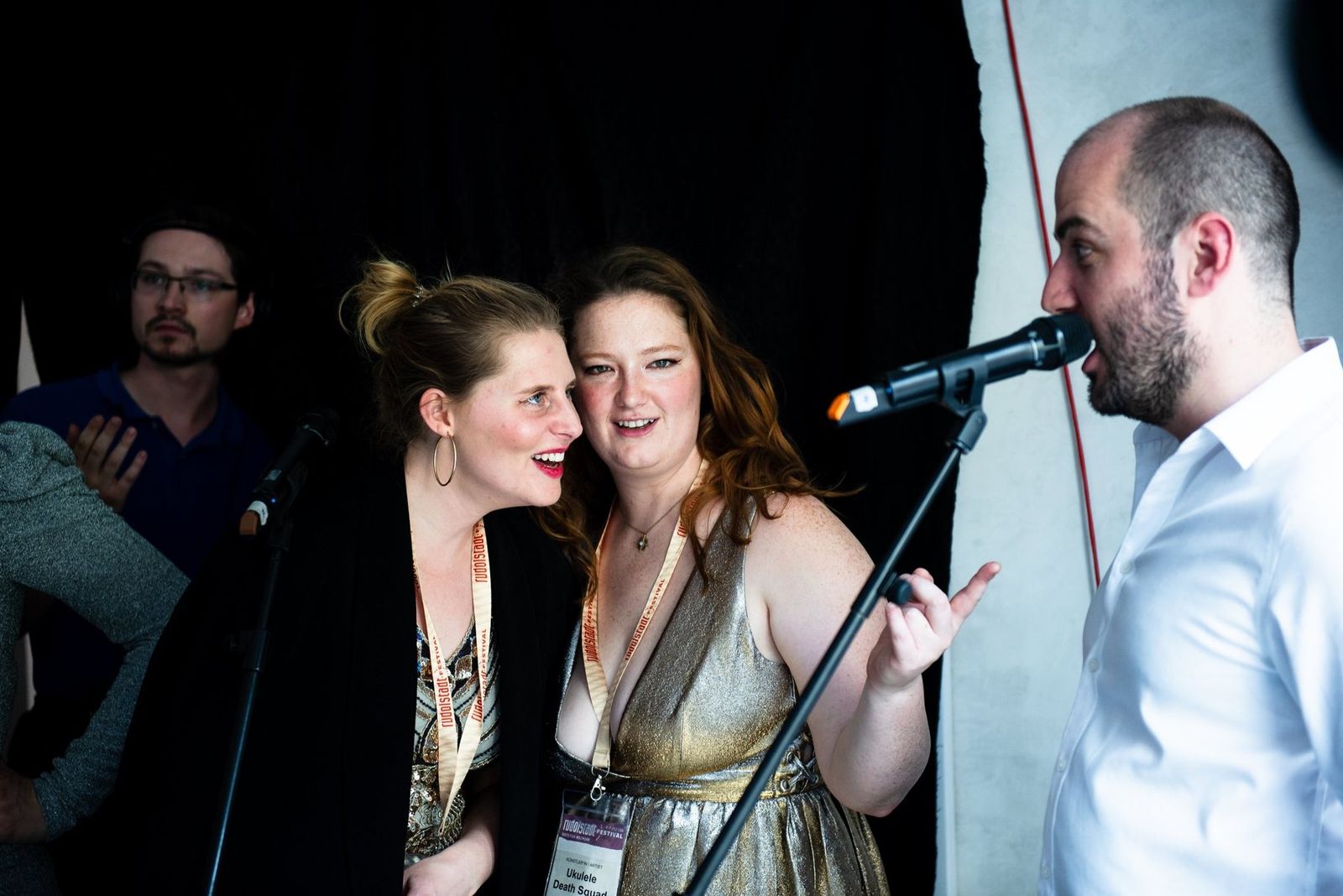 Two singers sharing a microphone in the radio studio