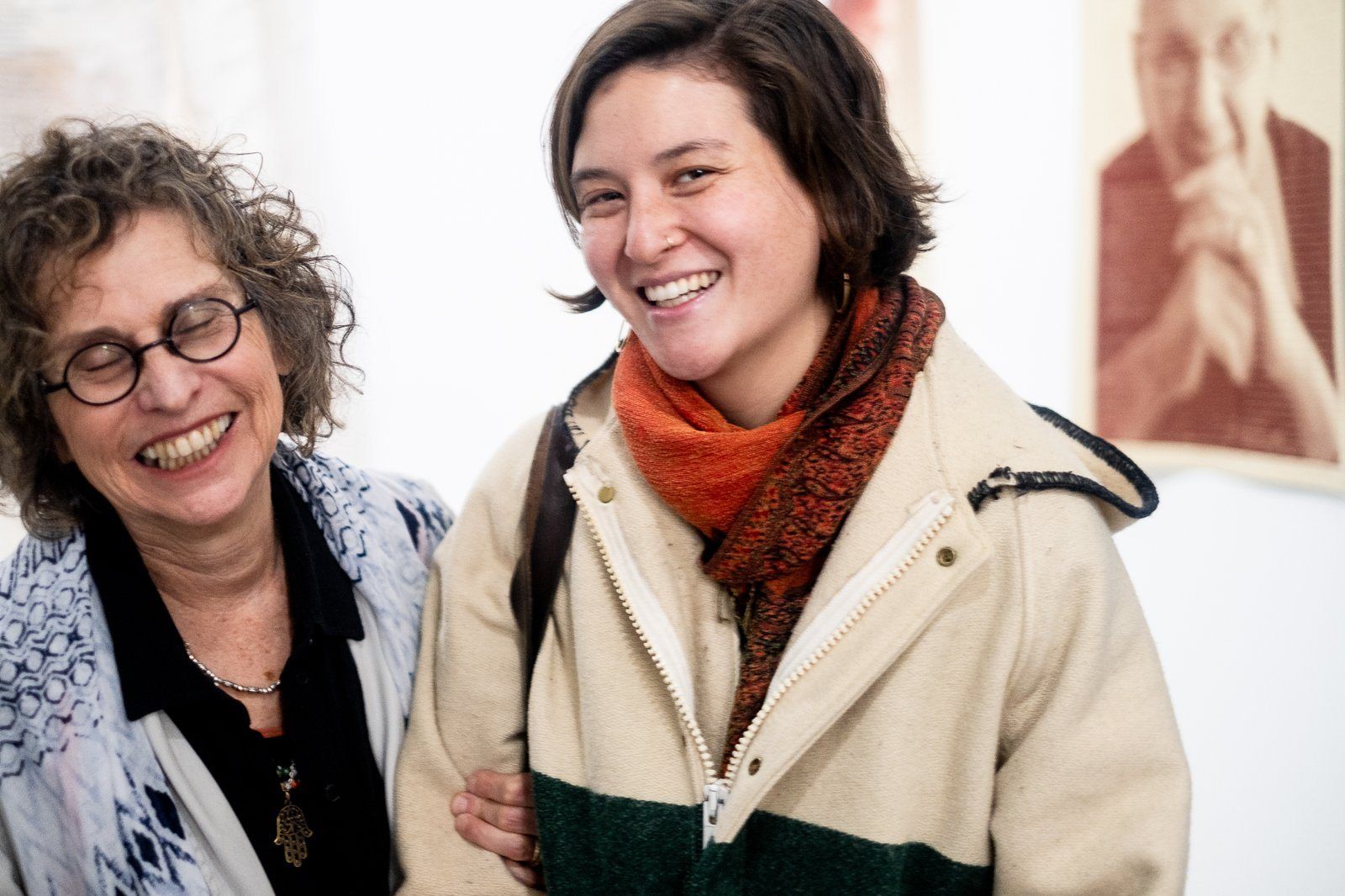 Two women laughing at an art opening