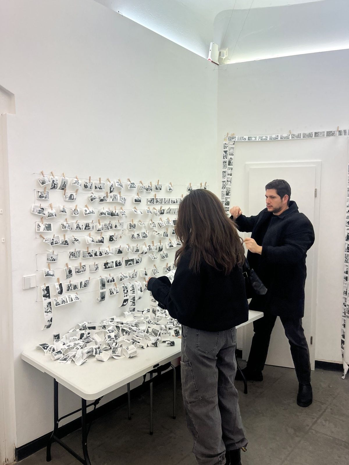 Visitors searching the wall of portraits for themselves