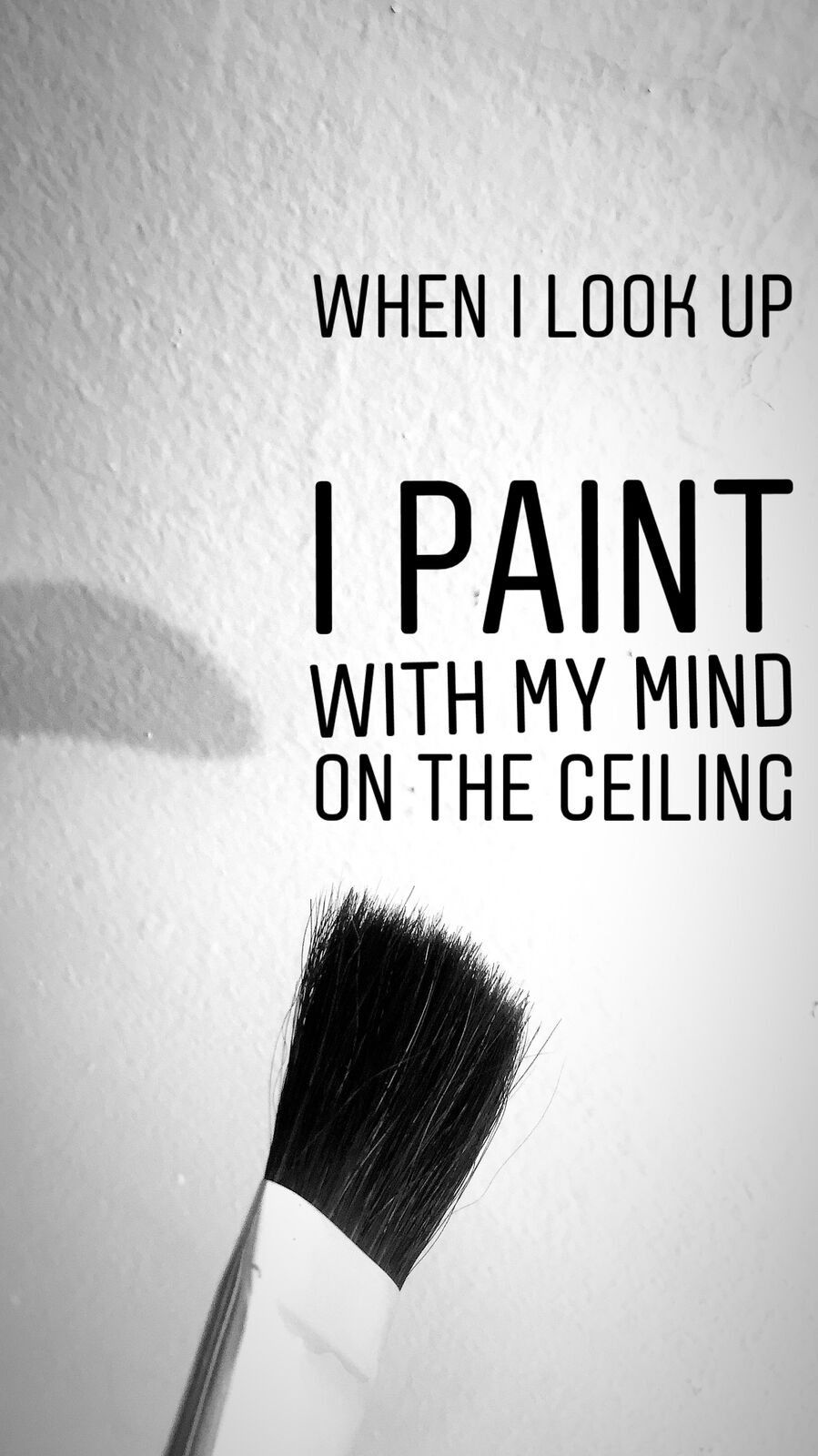 A paintbrush against a pale wall with the words When I look up I paint with my mind on the ceiling