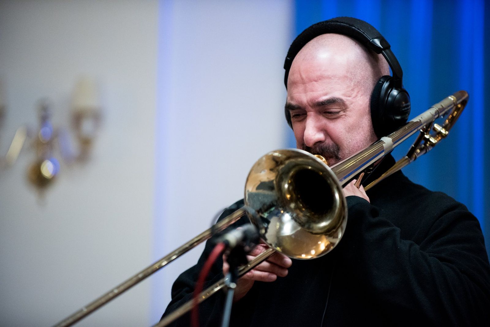 A trombonist recording in headphones